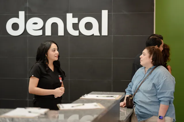 A 703 Dental team member helping a visitor at the Woodbridge, VA front desk