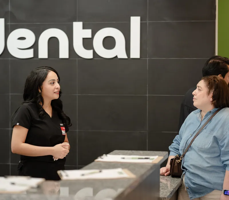 A 703 Dental team member helping a visitor at the Woodbridge, VA front desk